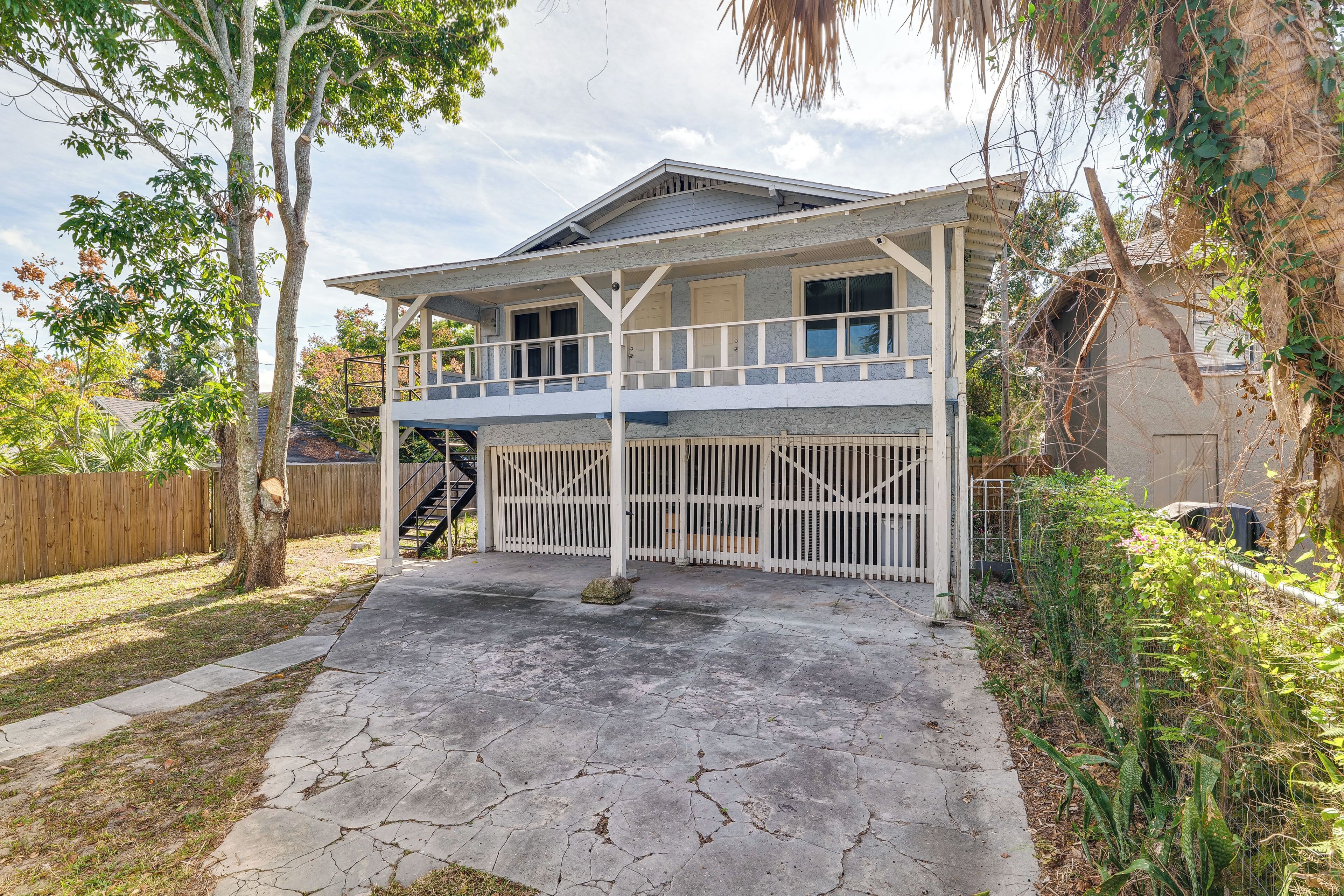 A two-story house with a covered porch and a fenced backyard.