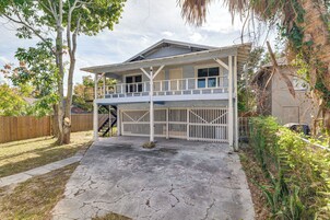 A two-story house with a covered porch and a fenced backyard.