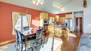A spacious kitchen with wooden cabinets, a dining area with a table and chairs, and a ceiling fan. - 1 Mi to Terry Peak! Black Hills Cabin Hideaway (Lead)