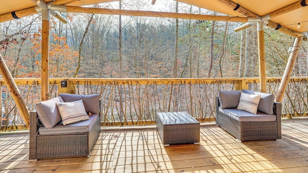 A covered outdoor seating area with two wicker sofas and a matching ottoman, overlooking a forested area. - Hikers Hideaway w/ Hot Tub Near Lookout Mountain (Trenton)