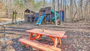 A playground with a slide and climbing structures, surrounded by trees. - Hikers Hideaway w/ Hot Tub Near Lookout Mountain (Trenton)