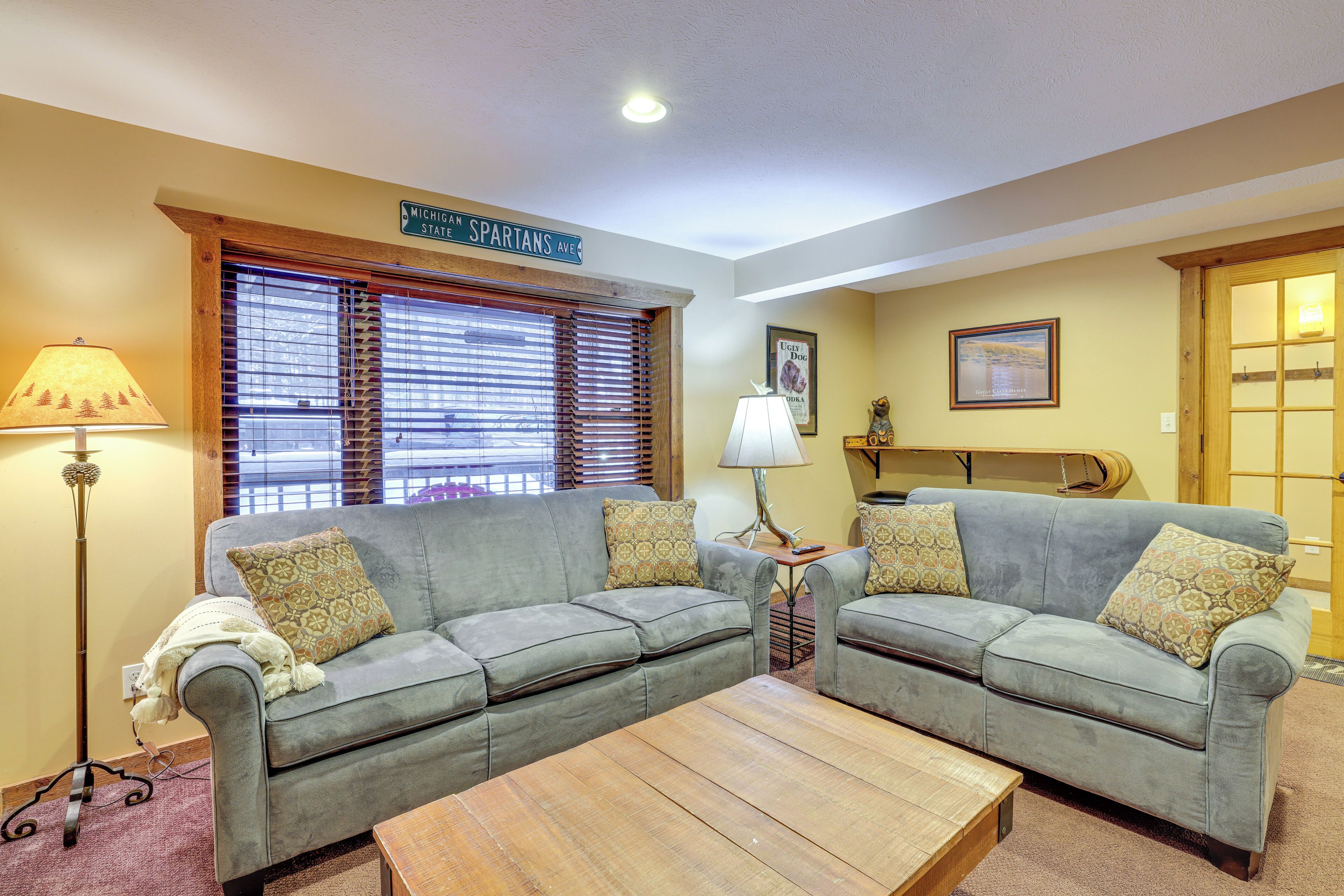 A living room with two grey sofas, a wooden coffee table, and a lamp.
