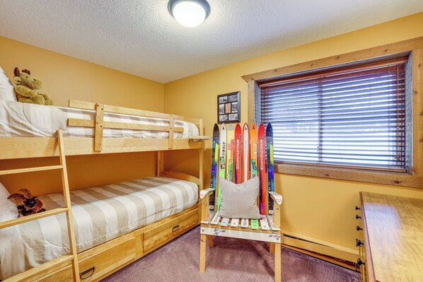 A bunk bed room with a window, a small desk, and a shelf with surfboards. - Crystal Mountain Cabin: Fall Views, Golf, Ski (Thompsonville)