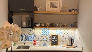 A compact kitchen with dark cabinets, a stainless steel refrigerator, a sink, and a wooden countertop. - SurfWay beach cottage - Your Cape beach getaway (Cape Town)