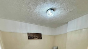 A room with a white table and chairs, a grey sofa, and a painting on the wall. - 3bedroom Entire House in Stockport Town Manchester (Stockport)