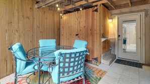 Una stanza con rivestimenti in legno, un tavolo e sedie in vetro, una porta con vetrata e un tappeto decorato.