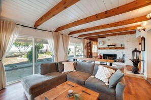 A cozy living room with a sectional sofa, a wooden coffee table, and a fireplace. - Spacious Riverside Farmhouse, Perfectly Located (Riverside)