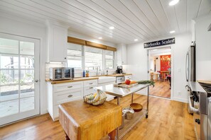 A modern kitchen with white cabinetry, a wooden countertop, and a stainless steel refrigerator. - Spacious Riverside Farmhouse, Perfectly Located (Riverside)