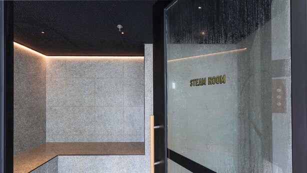 A steam room with a tiled floor, a bench, and a door labeled 'STEAM ROOM'. - Stunning Executive Suite with Heated Pool, Gym, Sauna, Steam, next to Crown (Southbank)