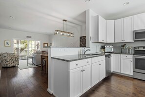 A modern kitchen with white cabinets, a granite countertop, and stainless steel appliances. - FAMILY FUN! Pool Community-Bike to Rehoboth Beach & Boards, 37005 Turnstone (Rehoboth Beach)