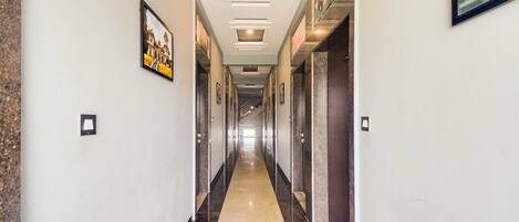 A long, narrow hallway with a polished floor and framed pictures on the walls.