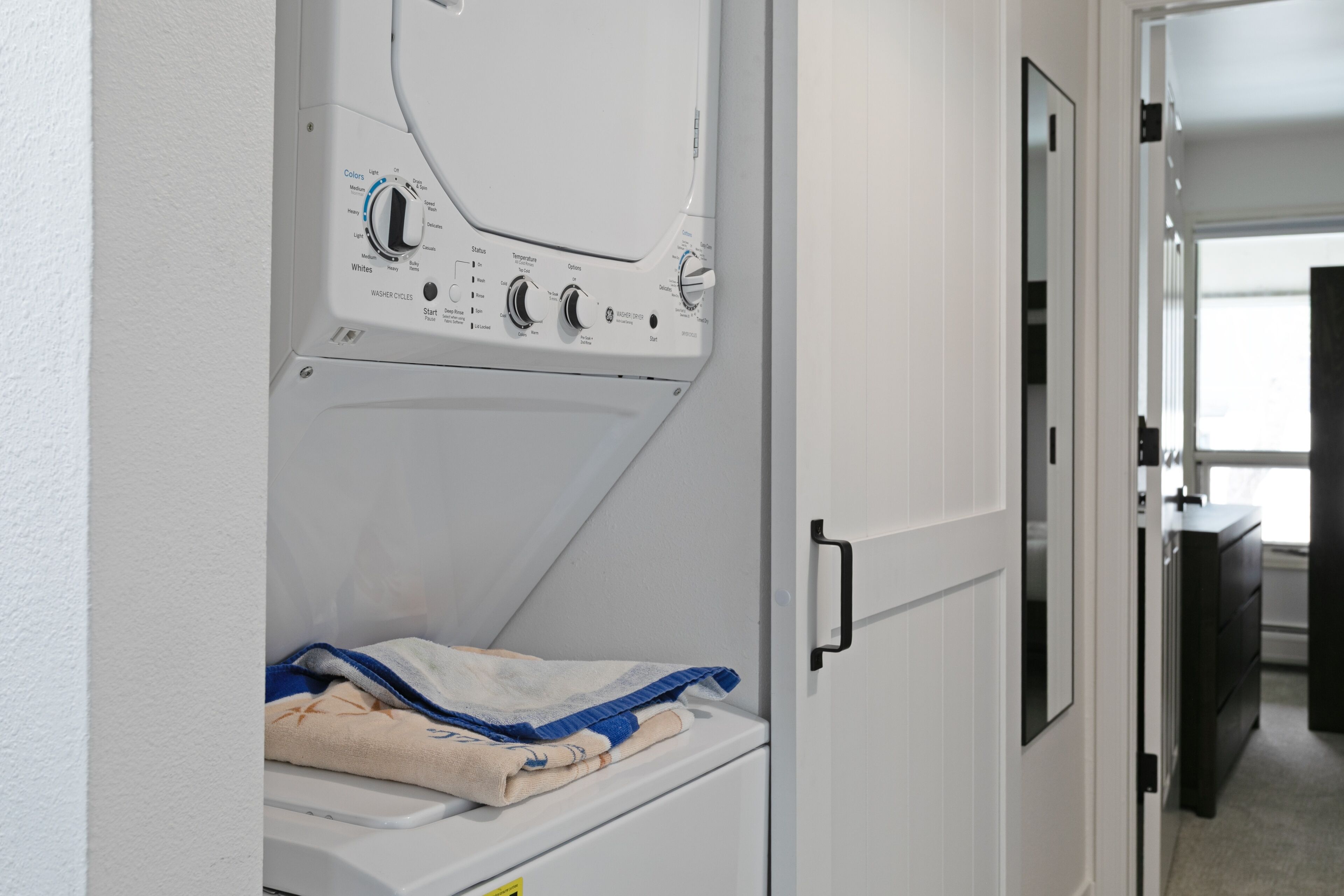 A laundry room with a washing machine, a dryer, and a folded towel on the dryer.