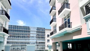 A swimming pool with blue tiles, surrounded by multi-story buildings with balconies. - Room-stylish Studio Stay at Saint Domini (Iloilo)
