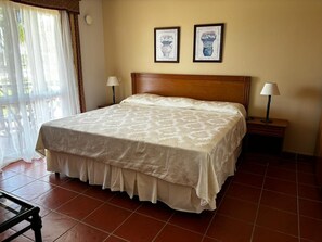 Habitación doble estándar, vista a la alberca | Minibar, caja de seguridad en la habitación y cortinas blackout 