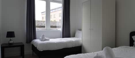 Tabla de planchar con plancha, internet y ropa de cama