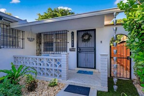 A residential house with a black front door, a white picket fence, and a mailbox. - Modern and Spacious 3BR - 2BA Miami - Free Parking (Miami)