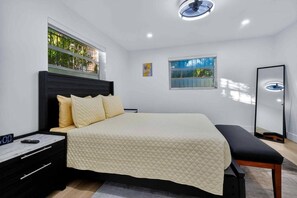 A modern bedroom with a bed, bedside table, and a nightstand. - Modern and Spacious 3BR - 2BA Miami - Free Parking (Miami)