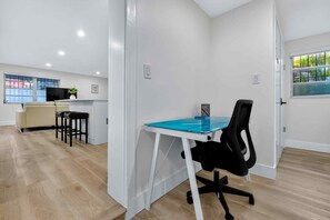A modern office space with a glass table, black office chair, and a beige sofa. - Modern and Spacious 3BR - 2BA Miami - Free Parking (Miami)