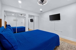 A bedroom with two beds, a TV, and a ceiling fan. - Modern and Spacious 3BR - 2BA Miami - Free Parking (Miami)