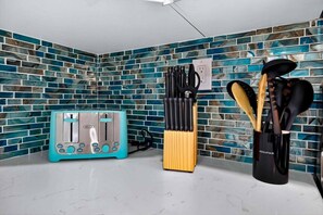A kitchen with a blue-tiled backsplash, a Della toaster, a knife block, and a coffee maker. - Modern and Spacious 3BR - 2BA Miami - Free Parking (Miami)