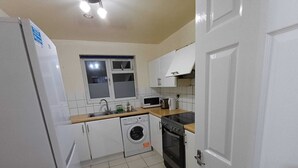 Cocina compacta con lavadora, microondas y horno.