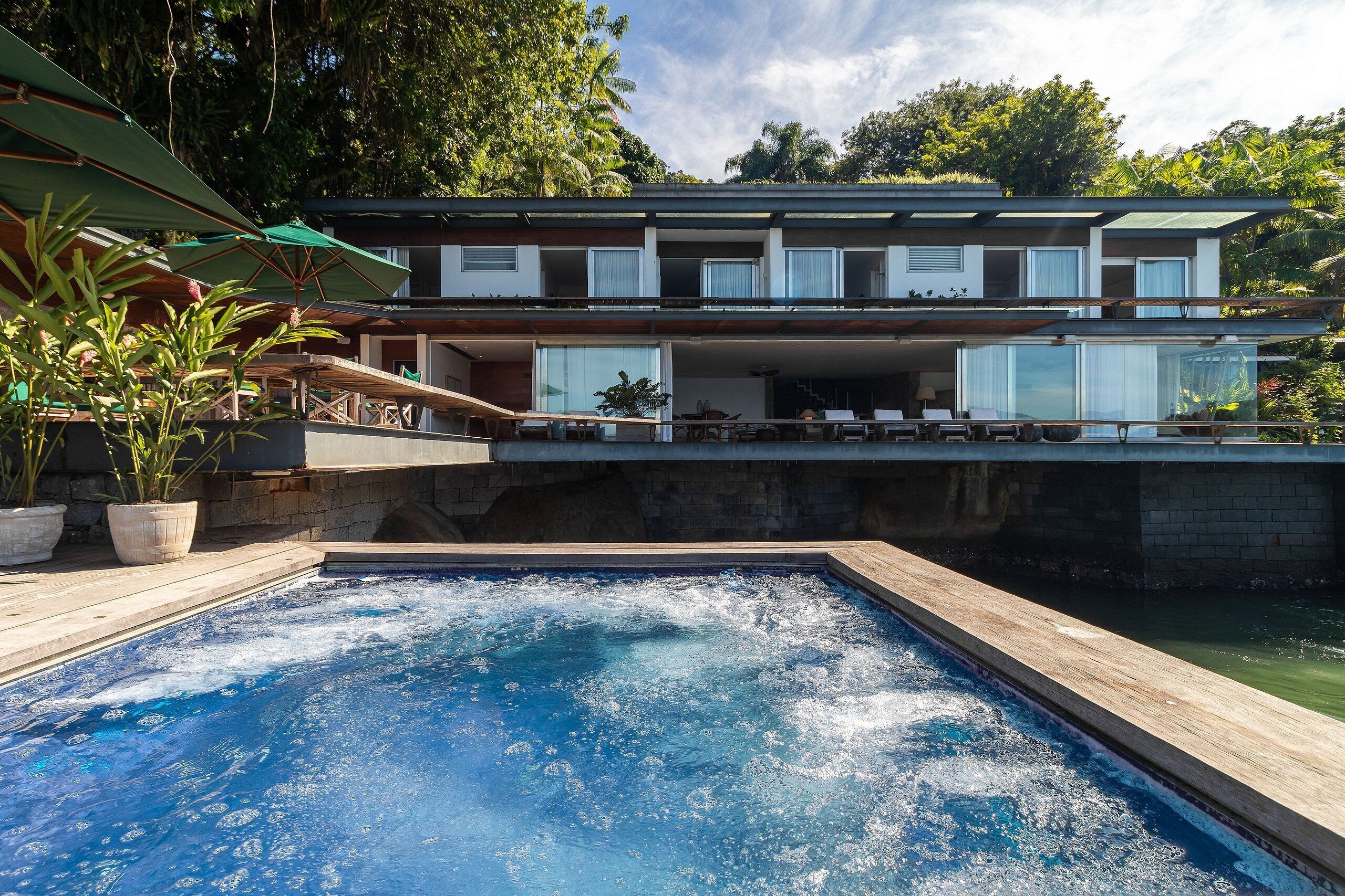 Villa | Alberca | Alberca al aire libre, sombrillas en la alberca y camastros 