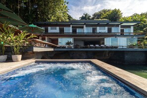 Villa | Zwembad | Een buitenzwembad, parasols bij het zwembad en ligstoelen