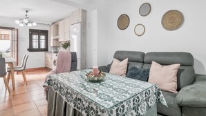 A living room with a sofa, a dining table, and a kitchen area in the background. - Apartment 'Mi Ilusión' with Wi-Fi (Grazalema)