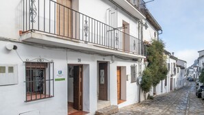 A narrow cobblestone street lined with white buildings, each with a balcony and a door marked with the number 30. - Apartment 'Mi Ilusión' with Wi-Fi (Grazalema)