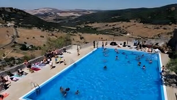A swimming pool with people in the water, surrounded by a landscape view. - Apartment 'Mi Ilusión' with Wi-Fi (Grazalema)