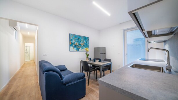 A modern apartment with a sofa, dining table, and kitchenette. - GuestHost - Cozy 60 sqm apartment, located on the first floor of a building without an elevator.The accommodation is situated in a strategic location, allowing you to reach the main points of interest within a short walking distance or by public transpor (Udine)