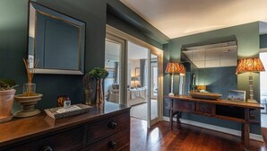 Una habitación con un aparador de madera, un espejo y un banco con lámparas.