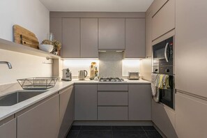 Eine moderne Küche mit Gasherd, Backofen und Mikrowelle.