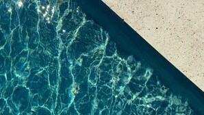 En klar pool med tydliga vågmönster i vattnet och en kant av betong.