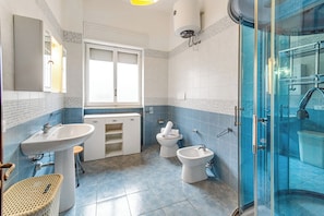 A bathroom with two sinks, a toilet, a shower, and a window. - Sunny Sea View (Melendugno)