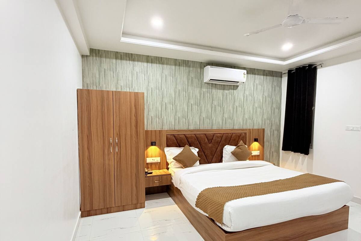 Une chambre moderne équipée d’un lit, d’une armoire, de lampes de chevet et d’un appareil de climatisation.