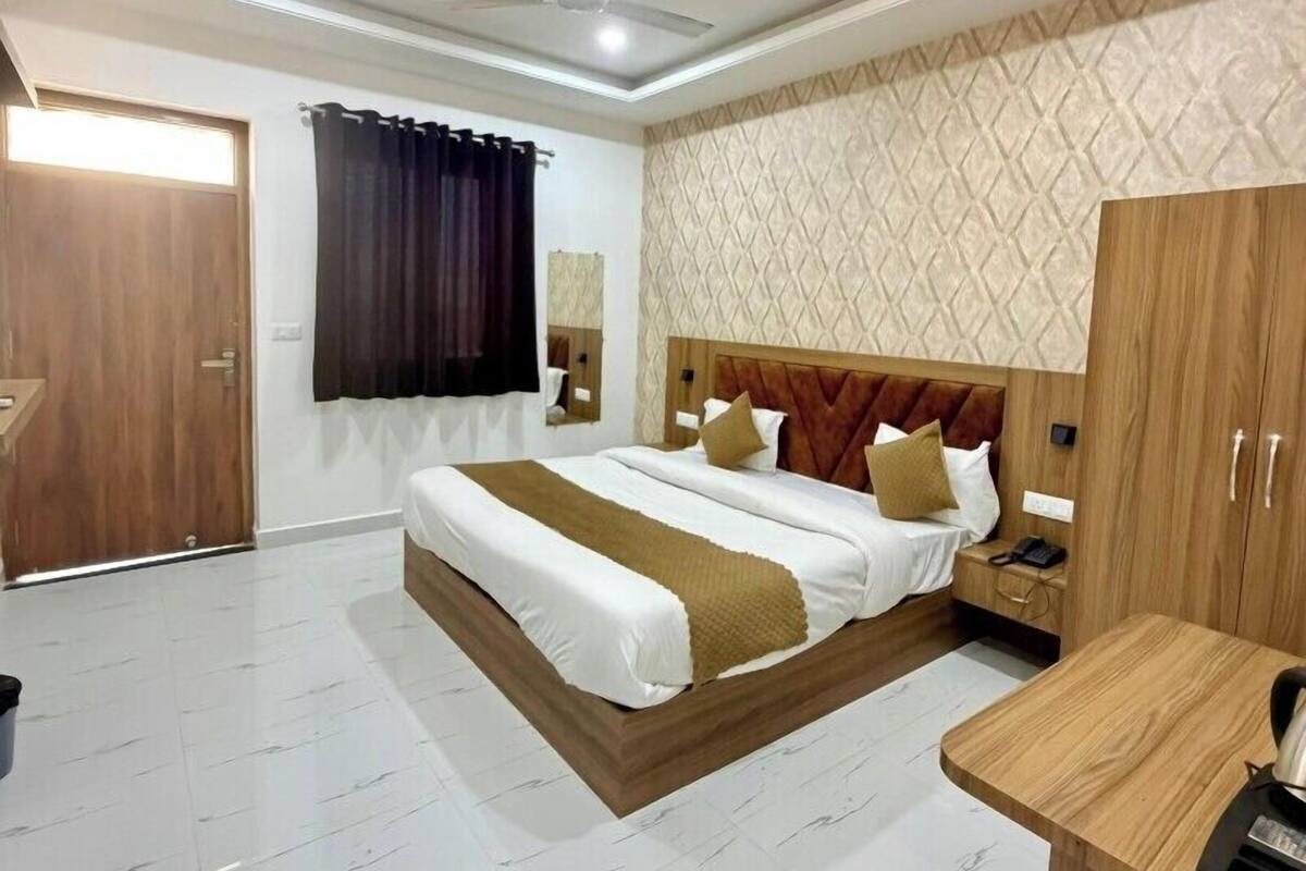 Une chambre d’hôtel équipée d’un lit, d’un bureau, d’une armoire et d’un ventilateur de plafond.