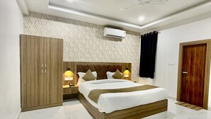 Un dormitorio con cama, armario, mesitas de noche, aire acondicionado y ventilador de techo.