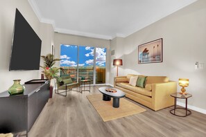 Ein modernes Wohnzimmer mit einer Couch, einem Couchtisch und einem an der Wand befestigten Fernseher.