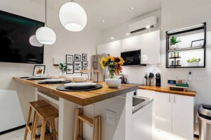 A modern kitchen with a central island, white cabinetry, and pendant lighting. - 1AS 5★ LUXURY FARM STAY BARNDOMINIUM - CEDAR POND FARMS - SCOTTISH HIGHLAND... (Jefferson City)
