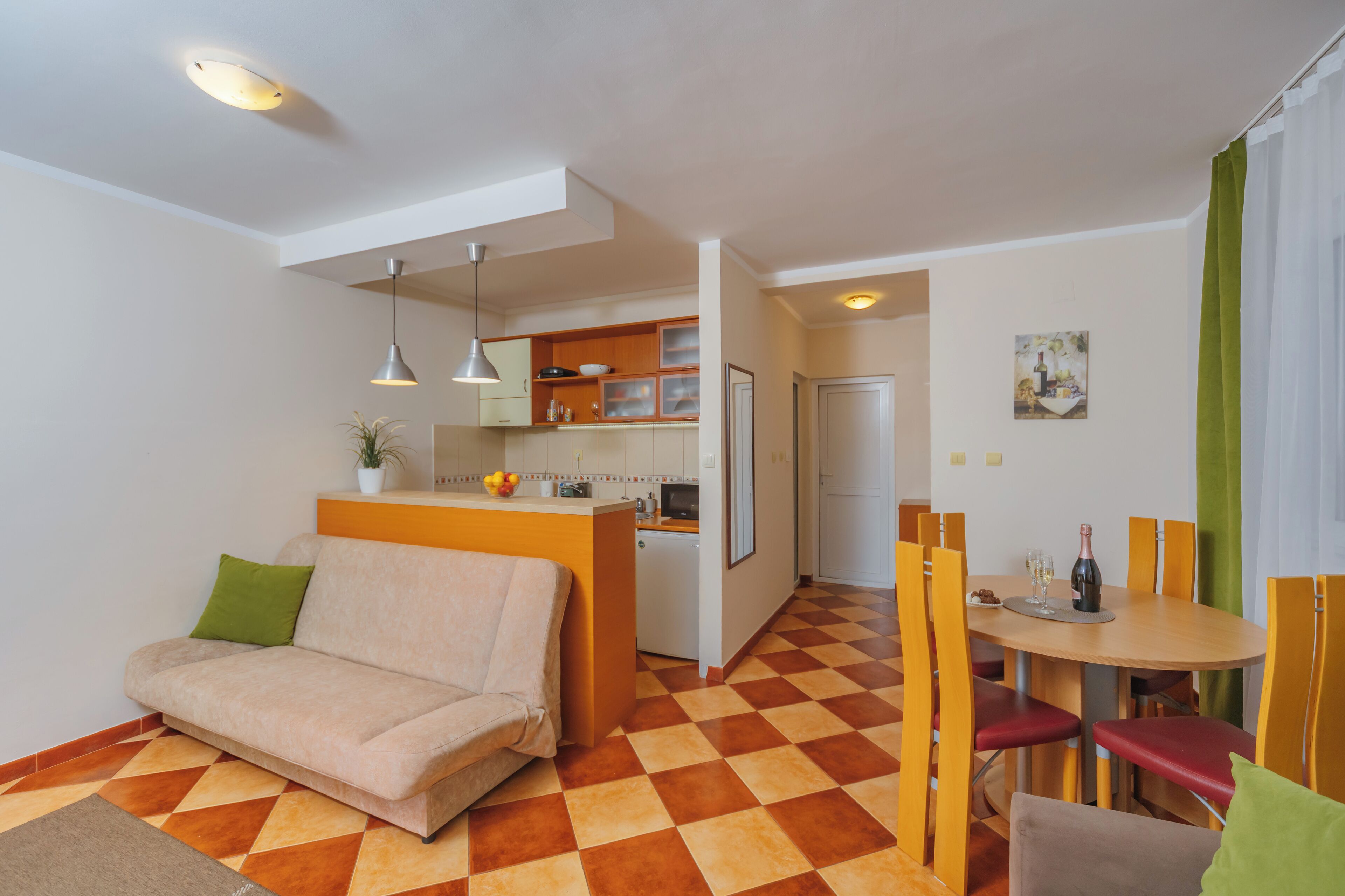 A compact living space with a sofa, dining table, and kitchen area.
