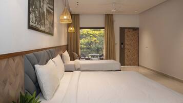 A modern bedroom with a large bed, a view of the outdoors through a window, and a door leading to another room.
