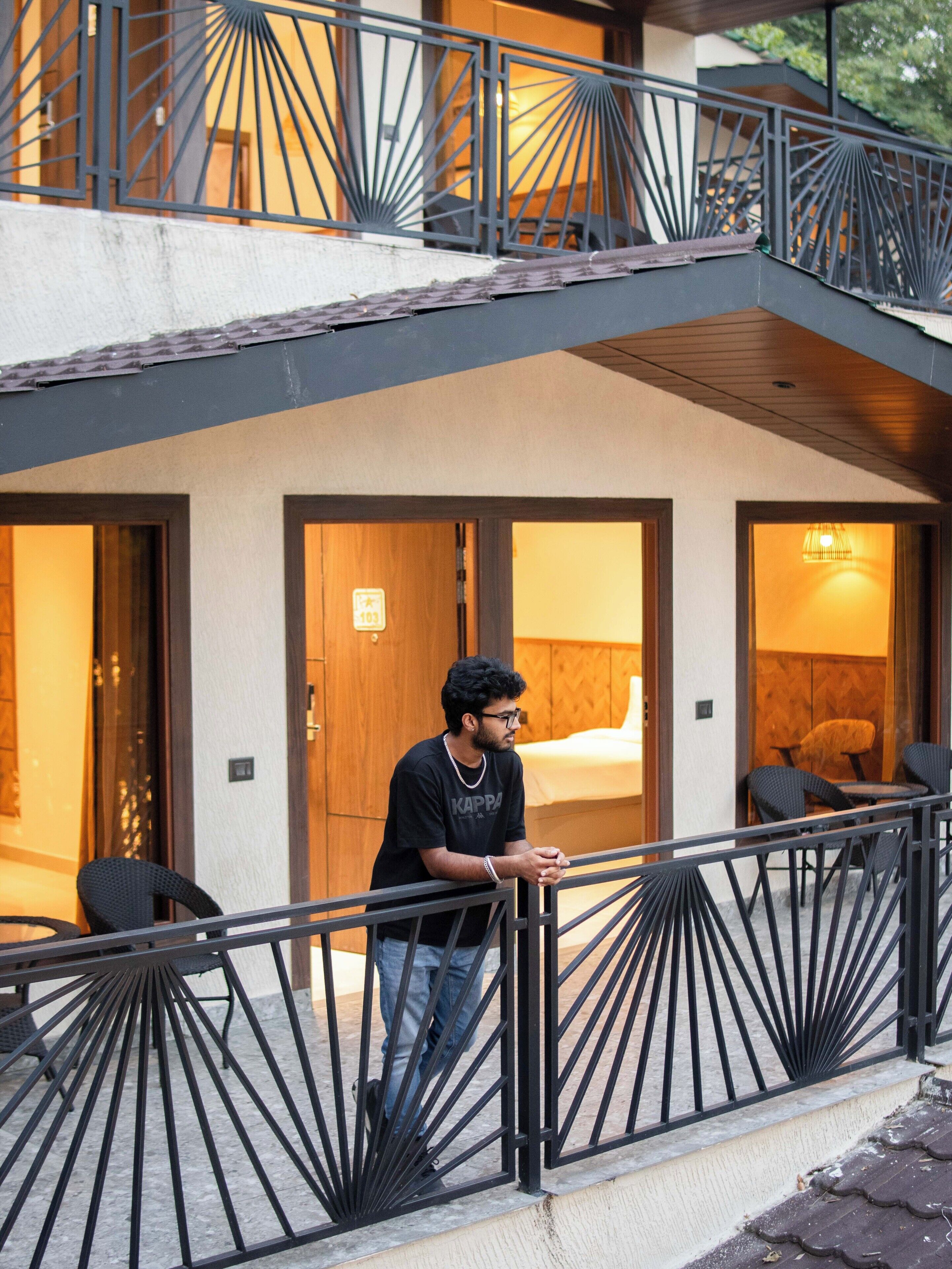 A hotel entrance with a modern design, featuring a metal railing and a wooden door.