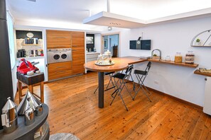 A compact kitchen with wooden flooring, a central island, and a built-in oven. - Host Monti del Sole (Santa Giustina)