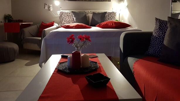 Ein Hotelzimmer mit einem Bett, einem Schreibtisch und einem Stuhl. Ein Fenster bietet Blick auf die Stadt.
