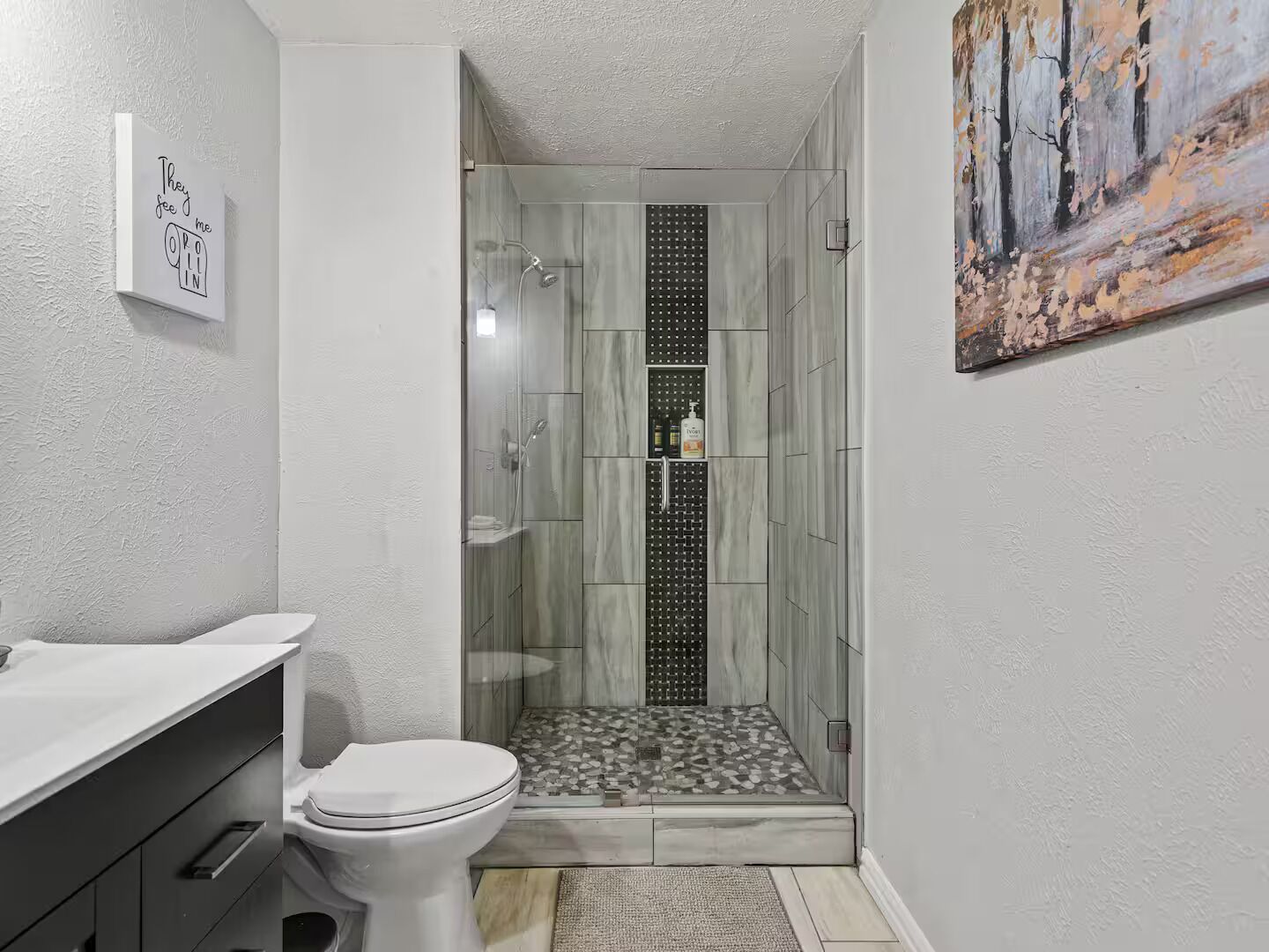 Une salle de bain avec une douche, des toilettes et un lavabo.