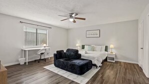 A bedroom with a bed, a desk, a chair, a ceiling fan, and a motivational quote on the wall. - 4BR Home w/ Arcade, Foosball & Desks - Carrollton (Carrollton)