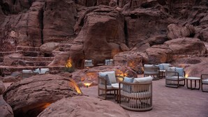 Jardín rocoso con área de estar al aire libre y un hogar para la chimenea.