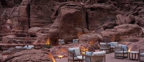 A rock garden with outdoor seating and a fire pit.