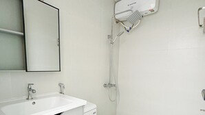 Une salle de bain moderne avec un lavabo blanc, un miroir et des toilettes.